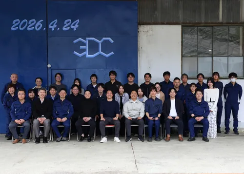 全社オフサイトの集合写真。3DC のロゴを背に全拠点のメンバーが並んでいる。