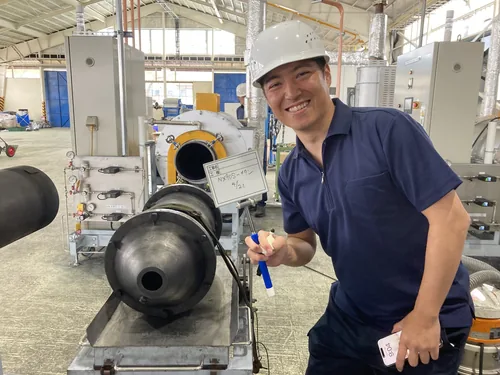 研究・製造体験会の様子。ヘルメット姿のメンバーが装置の前で作業している。