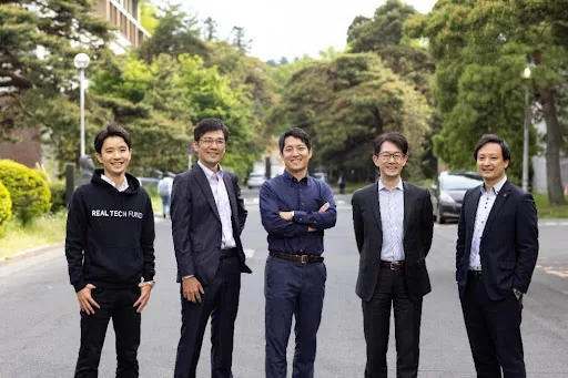 仙台本社のメンバー。東北大学構内の道路に5人が並んで立っている。